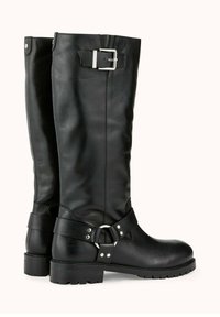 Bottes noires en cuir montant jusqu'au genou avec une semelle épaisse, ornées d'une boucle en argent et de détails en sangle. Texture lisse avec un léger éclat.