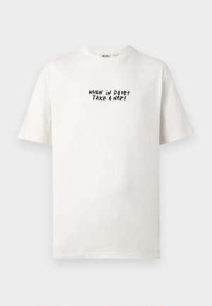 T-shirt blanc à manches courtes col rond avec texte noir "WHEN IN DOUBT TAKE A NAP!" imprimé sur la poitrine.