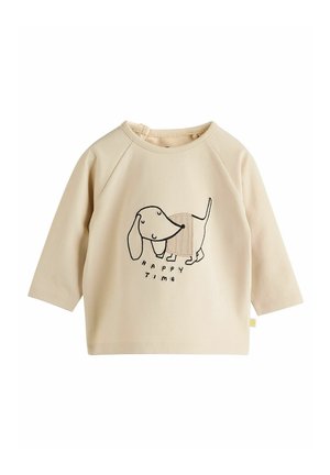 Chemise beige à manches longues avec col rond, arborant une illustration noire d'un teckel et le texte "HEUREUSE ÉPOQUE" en dessous. Texture de tissu douce.