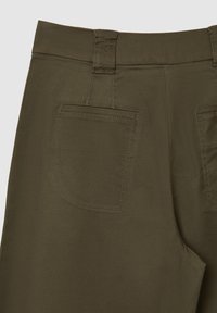 Pantaloni verde oliva con una texture liscia, dotati di una vita ampia e una tasca posteriore singola con dettagli di cucitura visibili.