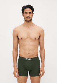 Grønne bomullsbokser med en tettsittende design, med en teksturert linning som har "Levi's"-logoen i sølv.