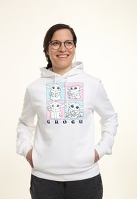 Biała bluza z kapturem z kolorową grafiką Grogu w czterech panelach na różowym i niebieskim tle. Napisy "GROGU" w granatowym poniżej.