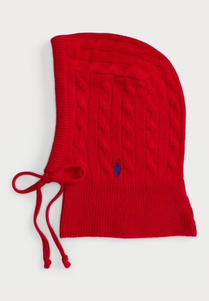 Rote Strickmütze mit einem Zopfmuster, geripptem Rand und Kordeln. Enthält ein kleines blaues Logo auf der Vorderseite. Weiche Textur.