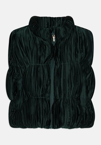 Dark green padded vest made from soft, textured fabric with a high collar and a front zipper. Features vertical pleats for visual detail.