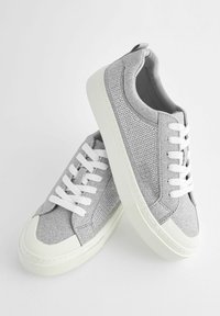 Grå sneakers i strukturerad textil med vita snören, en vit gummisåle och en subtil mönstrad finish på sidorna.