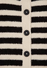 Černobíle pruhovaný pletený cardigan s pěti černými knoflíky, žebrovanou strukturou a střídajícími se širokými a úzkými pruhy.