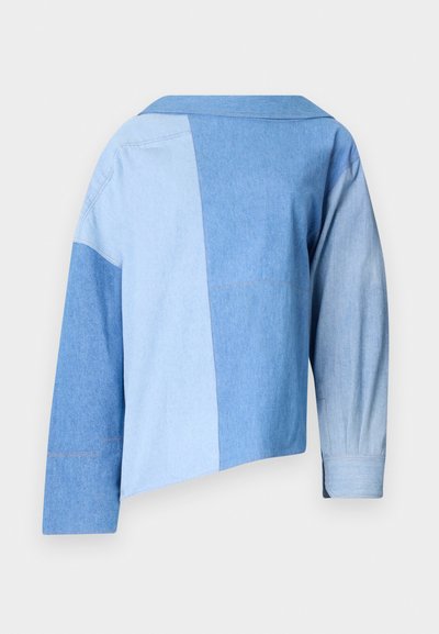 Blue denim cropped jacket featuring a patchwork design with varying shades of blue, a collar, and long sleeves with cuff detailing.