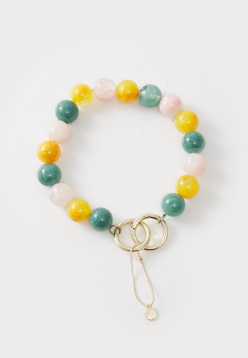 Pärlarmband med runda pärlor i grön, gul, rosa och orange, med en guldring som lås och en delikat kedja med en berlock.