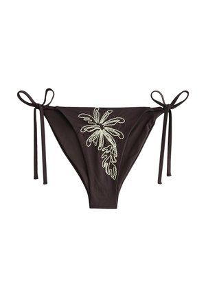 Bas de bikini noir avec des liens sur les côtés et un motif de feuille tropicale blanche brodée au centre avant.