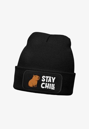 Black knitted beanie hat with a ribbed texture, featuring a rounded cuff and a patch that displays a capybara illustration and the text "STAY CHILL."