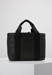 Bolsa tote negra tejida con superficie texturizada, forma rectangular, asas de tela duales y correas en negro contrastante.