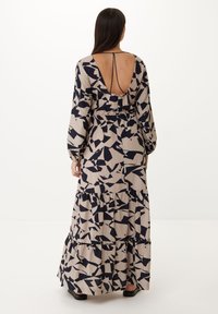 Maxi šaty v béžové barvě s námořnickým abstraktním vzorem; mají dlouhé rukávy, hluboký výřez na zádech a vrstvený volánkový lem. Hladká textilie.