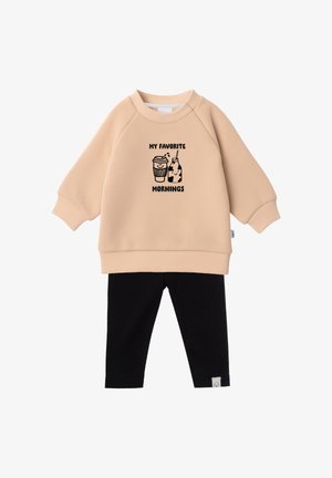 Beiger Langarm-Sweatshirt mit dem Text „My Favorite Mornings“ und einer Kaffeetassengrafik, kombiniert mit schwarzer Hose.