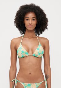 Bikini set in green with floral pattern, featuring a triangular top and ties on the sides. Material is smooth and stretchy.