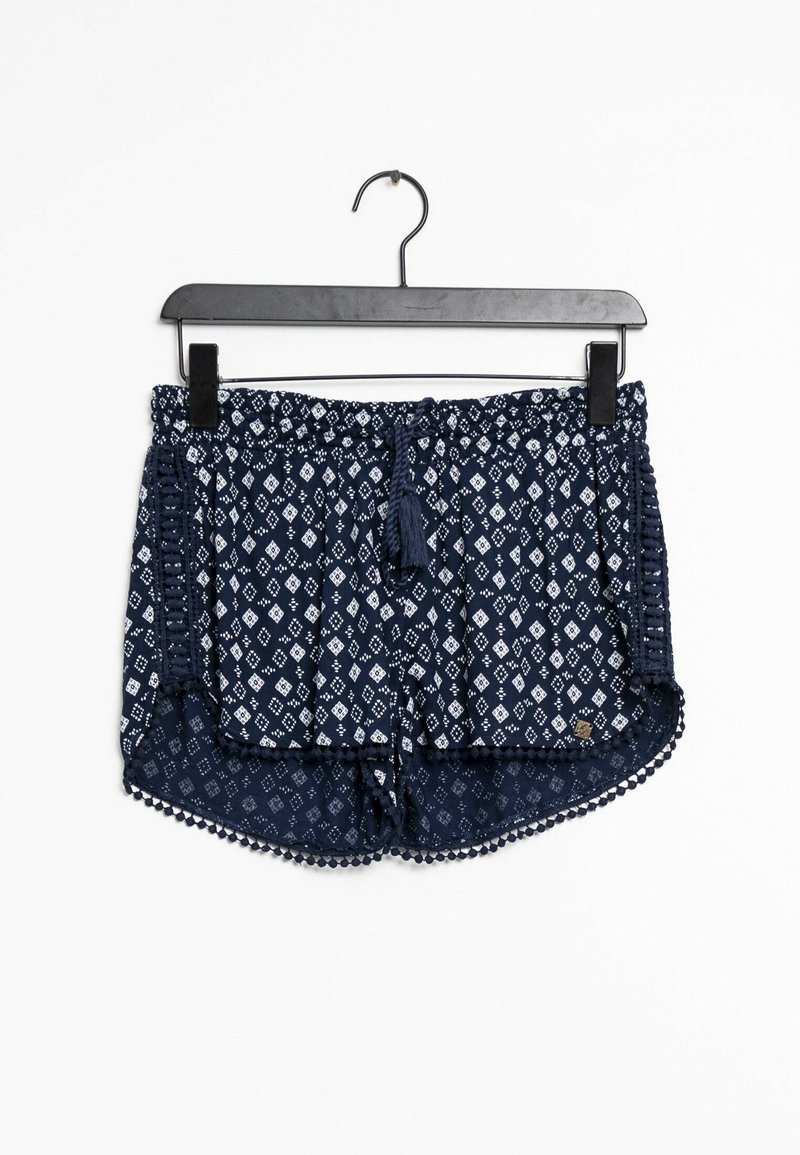 Shorts bleu marine à motifs avec des formes de diamants blanches, taille élastique, cordon de serrage à pompons et bordure en pompons le long de l'ourlet.