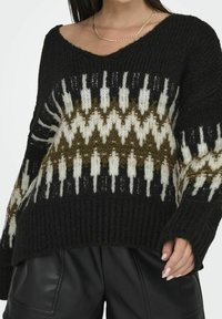 Schwarzer, gestrickter Pullover mit V-Ausschnitt, der ein geometrisches Muster in Weiß, Olivgrün und Creme aufweist. Dicke Textur mit gerippten Bündchen.