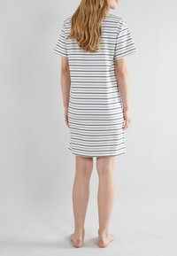 Abito bianco a maniche corte con righe orizzontali blu navy; vestibilità comoda, tessuto di cotone morbido, lunghezza a metà coscia, scollo rotondo, senza chiusure visibili.