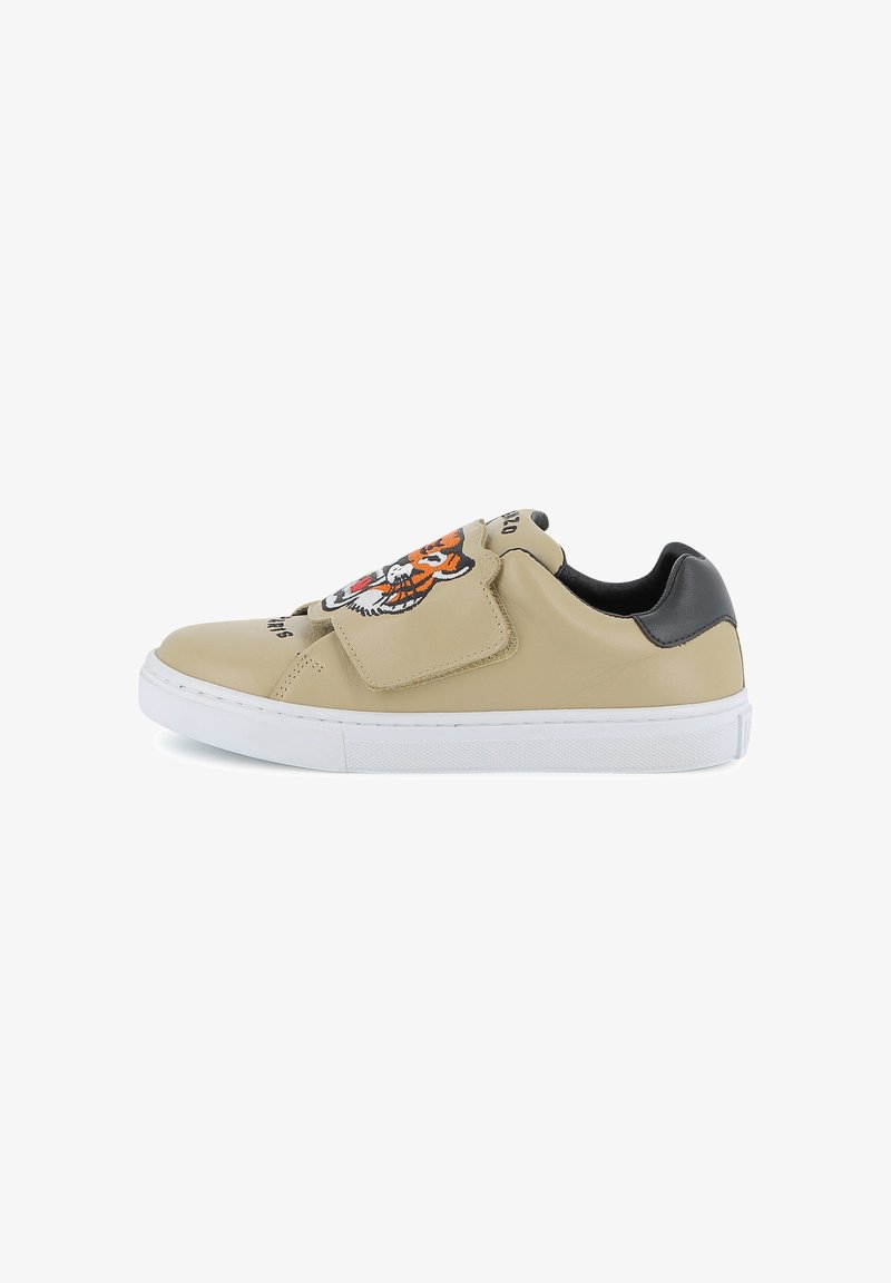 Baskets en cuir beige avec une semelle en caoutchouc blanche. Présentent un motif de tigre sur la tige et des accents noirs sur le talon et la sangle.