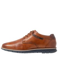 Chaussure en cuir marron avec une tige texturée, semelle en caoutchouc noire, design à lacets et accent de marque sur le côté. Forme de orteil arrondie.