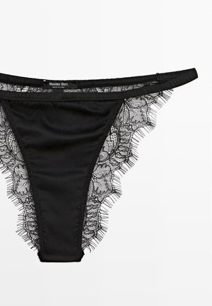 Zwarte string met ingewikkelde kantdetails langs de randen. Gladde stof met een zachte textuur, met een label dat zegt "Massimo Dutti."