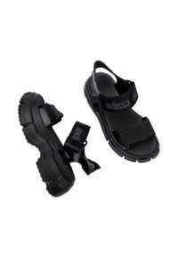 Czarne sandały z grubymi, teksturowanymi podeszwami, z regulowanymi paskami i akcentem z logo. Wykonane z materiałów syntetycznych dla większej trwałości.