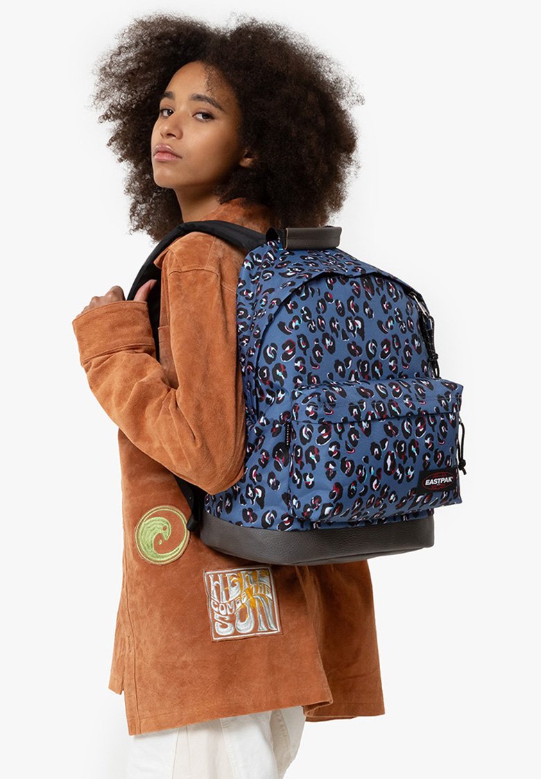 Mochila azul con un diseño de manchas de leopardo, correas de hombro acolchadas y una base negra. Equipado con un bolsillo frontal y etiqueta de la marca.
