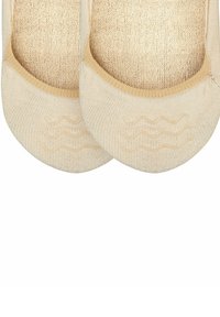 Beige onzichtbare sokken van een zachte, gestructureerde stof met een rubberen golfpatroon op de zolen voor verbeterde grip.