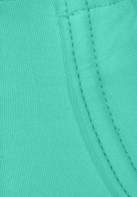 Lichtblauwe stof met een ribbelstructuur, voorzien van zichtbare stiksels langs de naden en een gladde, rekbare oppervlakte.