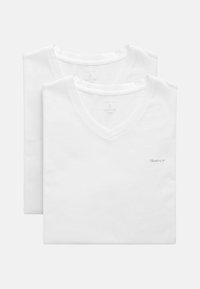 Zwei weiße V-Ausschnitt-T-Shirts aus Baumwolle. Mit einem kleinen grauen Logo auf der Brust. Weicher Stoff, klassischer Schnitt und kurze Ärmel.