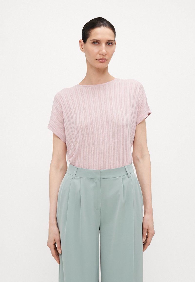 Blusa de rayas rosa claro con escote redondo y mangas cortas, combinada con pantalones de pierna ancha en color verde menta. Textura de tela suave.