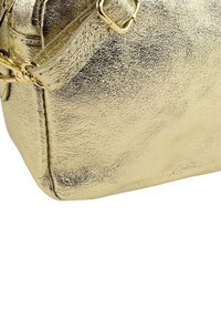 Gouden metallic handtas met een gestructureerd oppervlak, een rechthoekige vorm, een veilige ritssluiting aan de bovenkant en een afneembare riem.