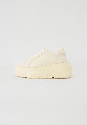 Platform sneakers in smooth cream leather, featuring a rounded toe, lace-up front, and textured rubber sole with logo detail.