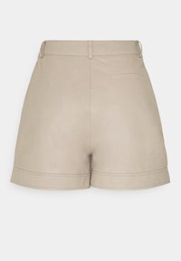 Short en cuir beige taille haute avec passants de ceinture, une poche arrière et des ourlets pliés, présenté de dos sur un fond uni.