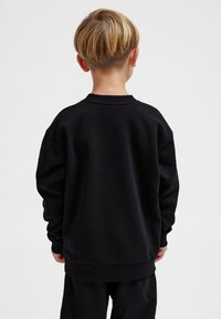 Svart sweatshirt i tjock bomull, med långa ärmar, rund halsringning och en avslappnad passform, samt ribbade ärmslut och nederkant.