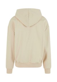 Beige hooded sweatshirt with a relaxed fit, ribbed cuffs and hem, soft texture, and a seamless design, featuring a central back seam.
