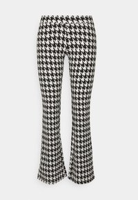 Svart och vit houndstooth-mönstrad flarebyxor med elastisk midja, med en slät textur och åtsittande silhuett.