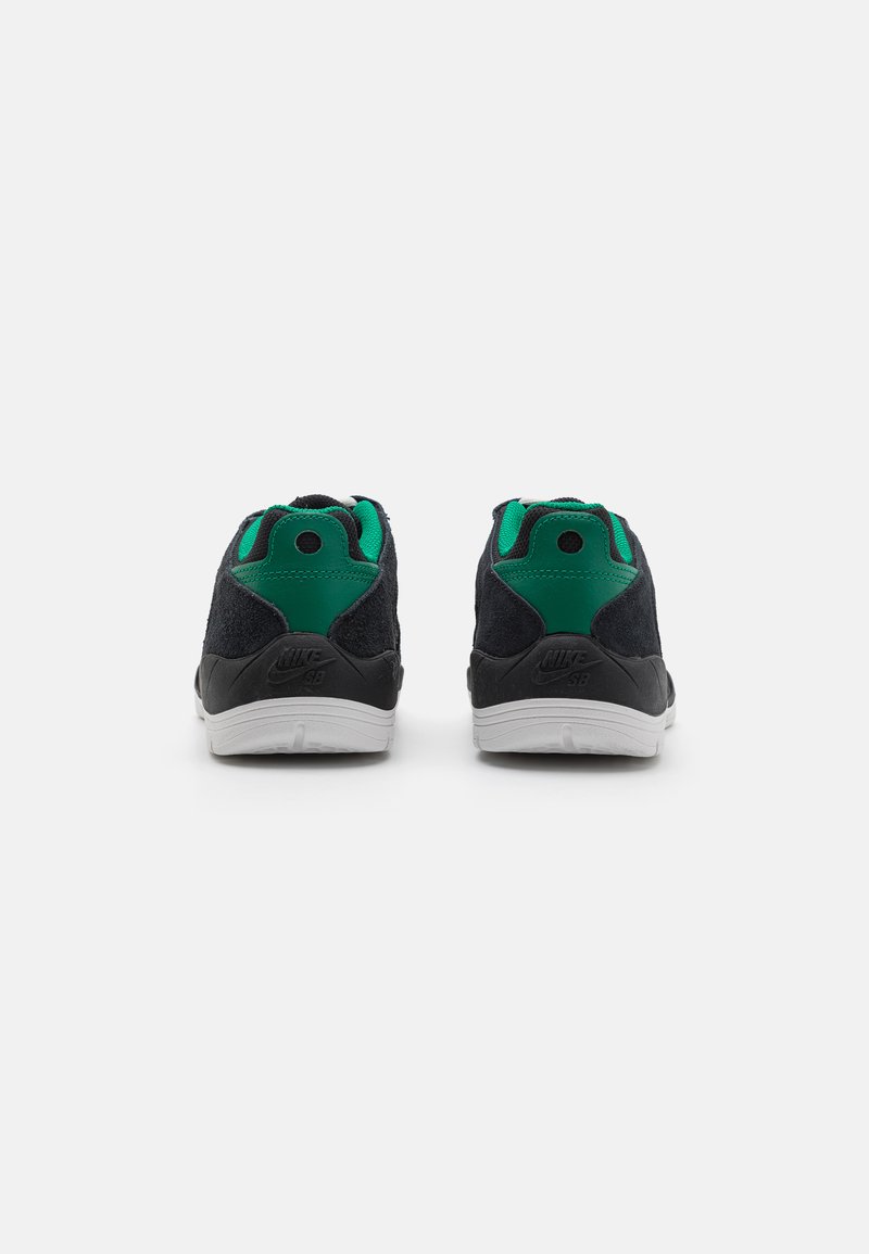 Schwarze Wildleder-Sneaker mit grünen Akzenten an Kragen und Ferse. Weiße Gummisohle mit Branding auf der Rückseite. Paar von hinten gezeigt.