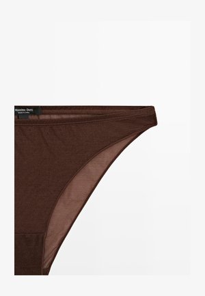 Brun bomulds-thong med en glat tekstur, der har et minimalistisk design og en talje-elastik. Mærkeetiketten er synlig på venstre side.