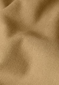 Tessuto intrecciato di un colore beige sabbioso con un fine motivo testurizzato, che mette in mostra una superficie morbida e ondulata.