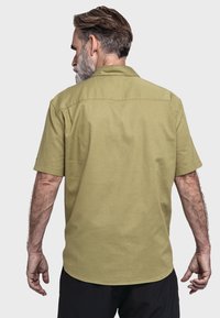 Kurzarmhemd aus hellolivgrünem Stoff, mit Schulterpasse und lässiger Passform. Glatte Textur mit klassischem Kragen und schlichtem Design.