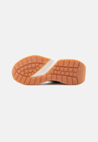 Semelle de chaussure avec une bande de caoutchouc orange présentant des motifs de feuilles et une bande blanche au centre avec la marque "DSQUARED2".