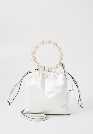 White satin drawstring bag with a pearl-embellished circular handle, leather accents, and a detachable strap for versatility.