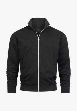 Svart zip-up hettegenser med høy krage, laget av glatt stoff. Har en liten logo på brystet og elastiske mansjetter.