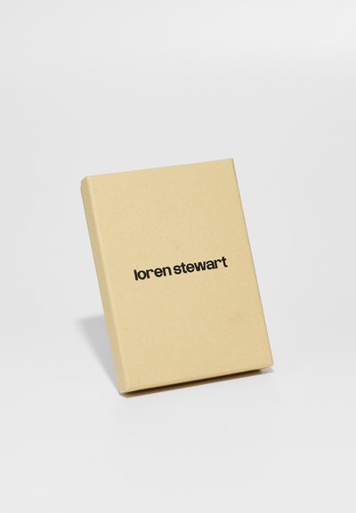 Rudas kartonas su lygiu paviršiumi ir stačiakampio forma, ant priekio turintis prekės ženklą "loren stewart" juodomis raidėmis.