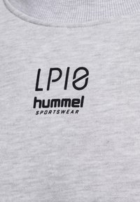 Gros plan sur un tissu gris clair avec les logos imprimés "LP10" et "hummel SPORTSWEAR" sur un matériau de vêtements de sport.