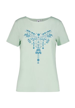 Lichtgroene T-shirt met korte mouwen, voorzien van een blauw geometrisch patroon dat in het midden van de voorkant is geplaatst, met diverse vormen en patronen.