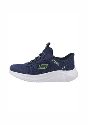 Zapatilla tipo slip-on de Skechers en azul marino con parte superior de malla, logo verde, suela gruesa blanca y cordones elásticos para un uso fácil.