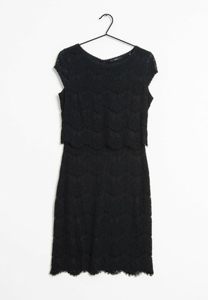 Czarna sukienka z koronką i krótkimi rękawkami na czarnym wieszaku na białym tle.