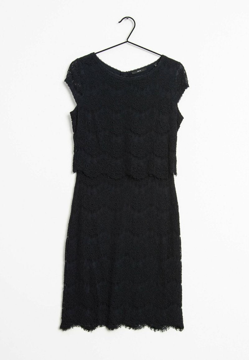 Robe en dentelle noire à manches courtes portée sur un cintre noir contre un fond blanc.