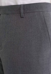 Šedé tailored kalhoty z texturované tkaniny, s plochým předním dílem, poutky na opasek a bočními kapsami. Čistý, profesionální střih.